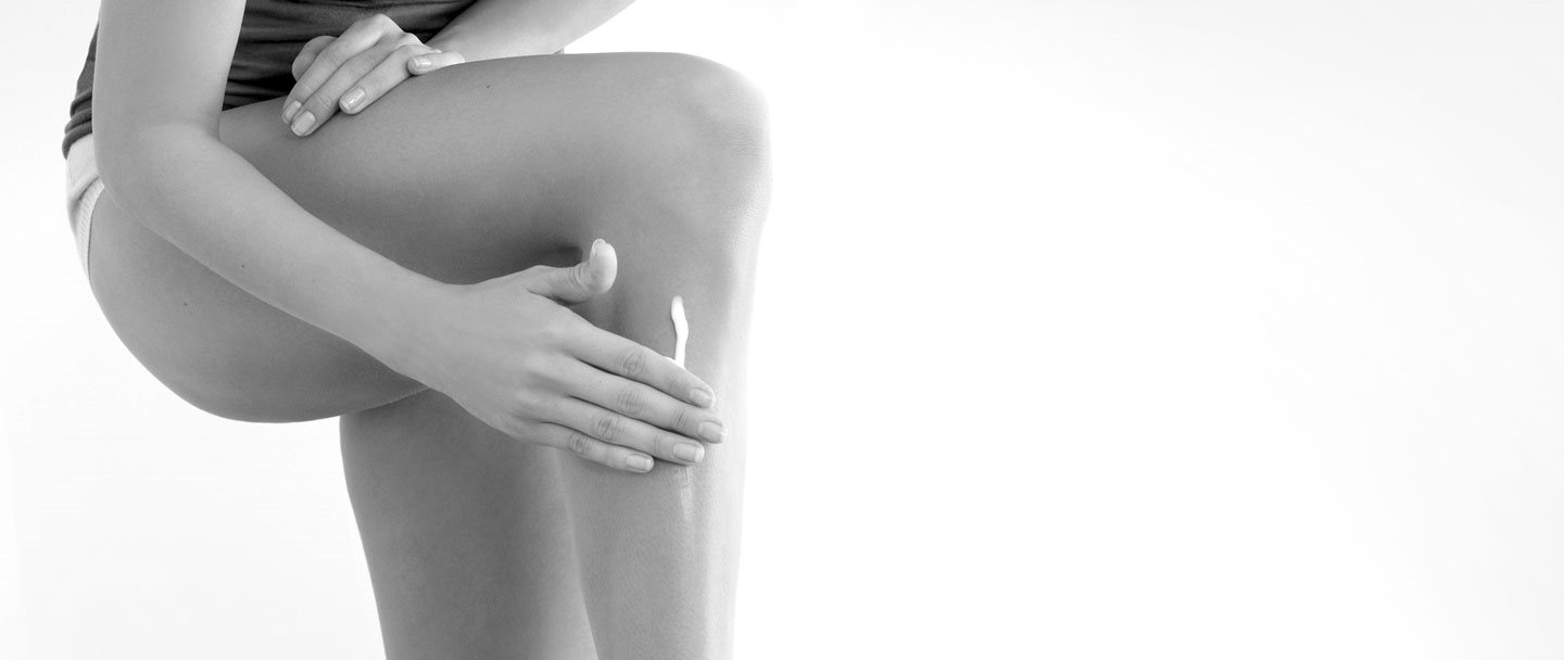 Mujer tocándose la pierna izquierda